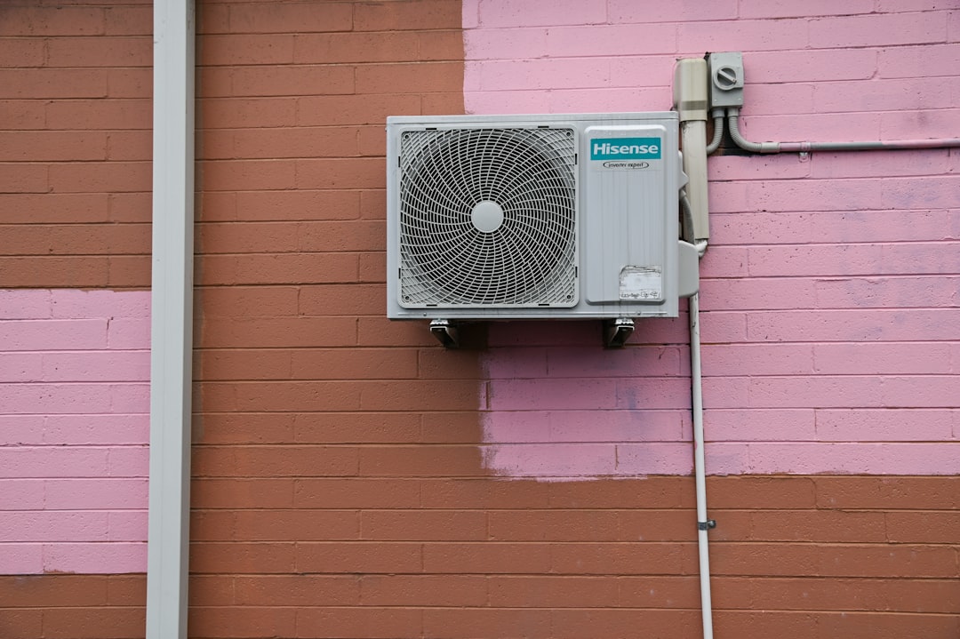 technician installing a small conduit through an exterior wall for a mini split system - what is a ductless mini split system technician installing a small conduit through an exterior wall for a mini split system - what is a ductless mini split system