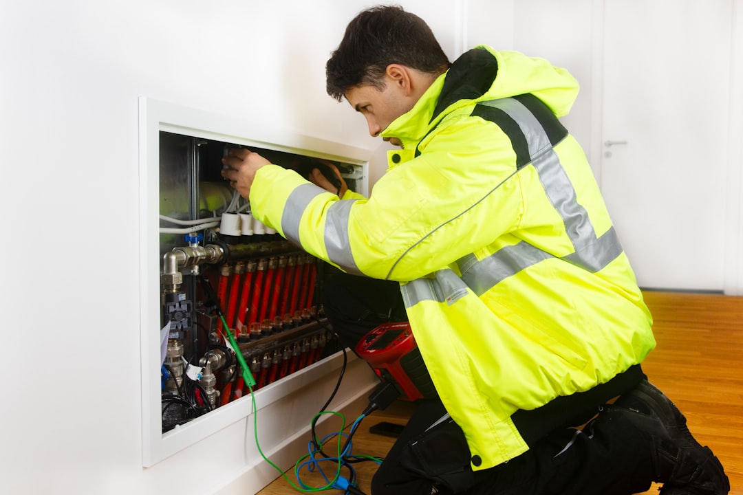 Licensed electrician inspecting a 200-amp electrical panel for EV capacity Licensed electrician inspecting a 200-amp electrical panel for EV capacity