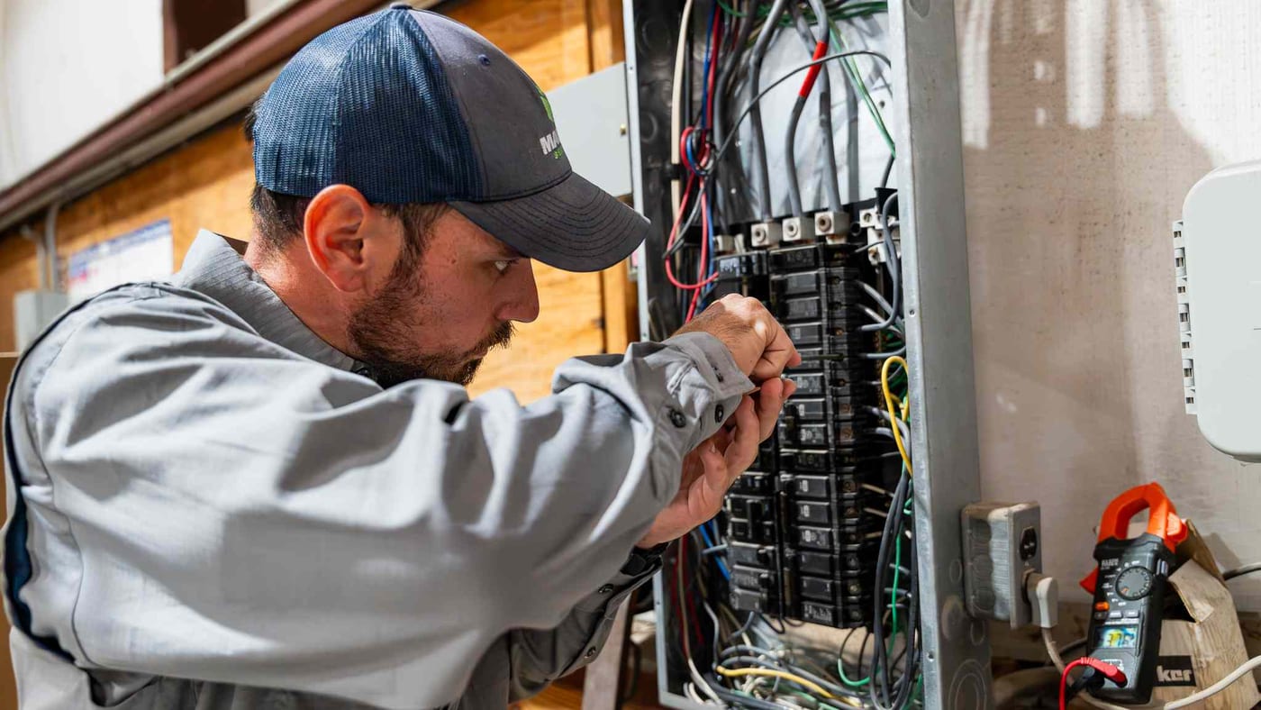 Mackey Services electrician working inside a residential electrical panel