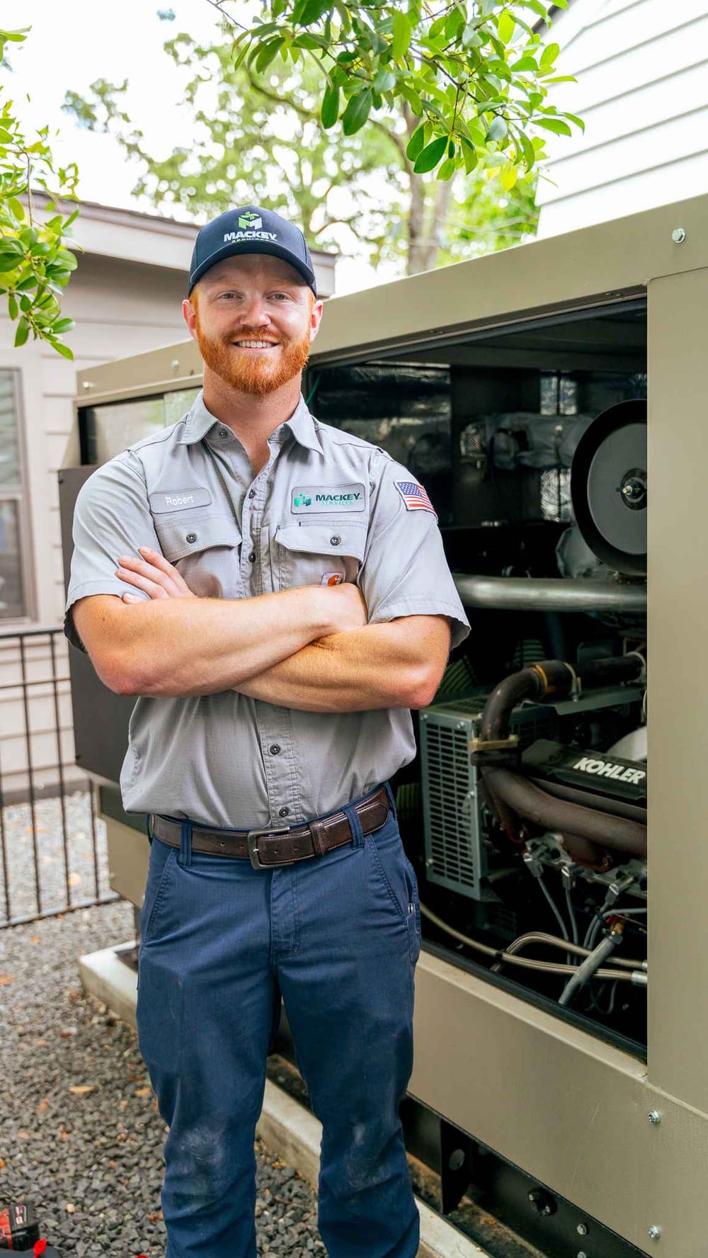 Mackey Services technician standing beside an installed standby generator