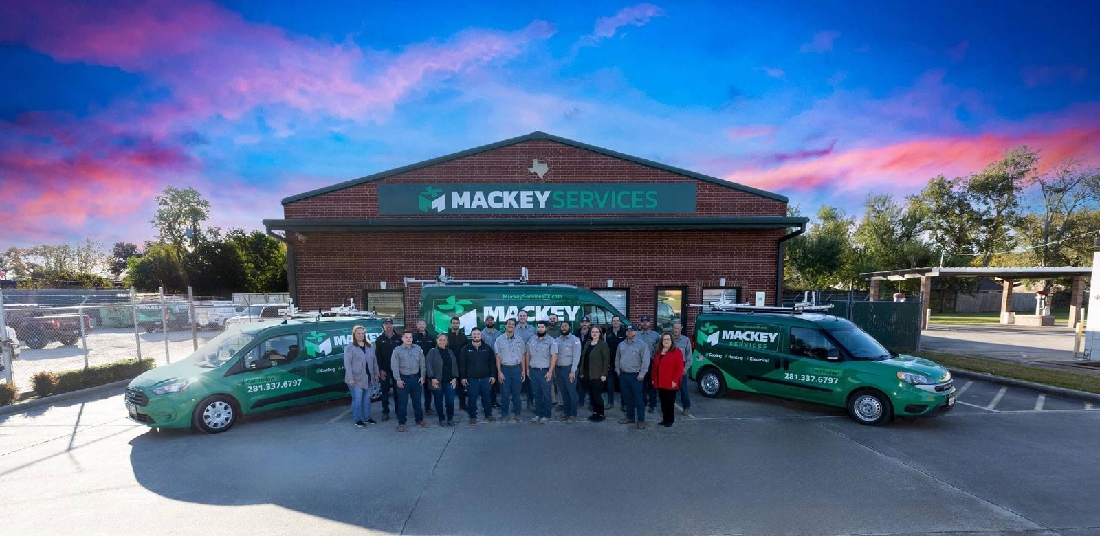 The Mackey Services team standing with the service fleet outside the shop on FM 517 in Dickinson, TX