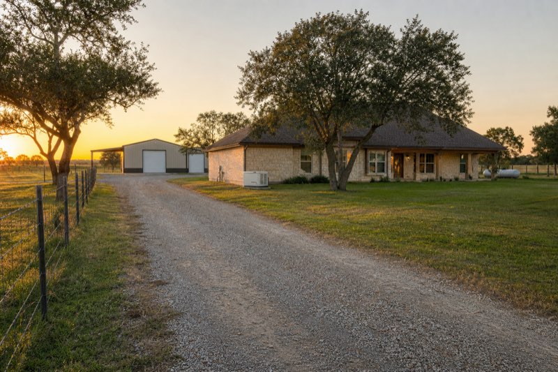 Rural Texas acreage home with metal workshop building and standby generator on a pad